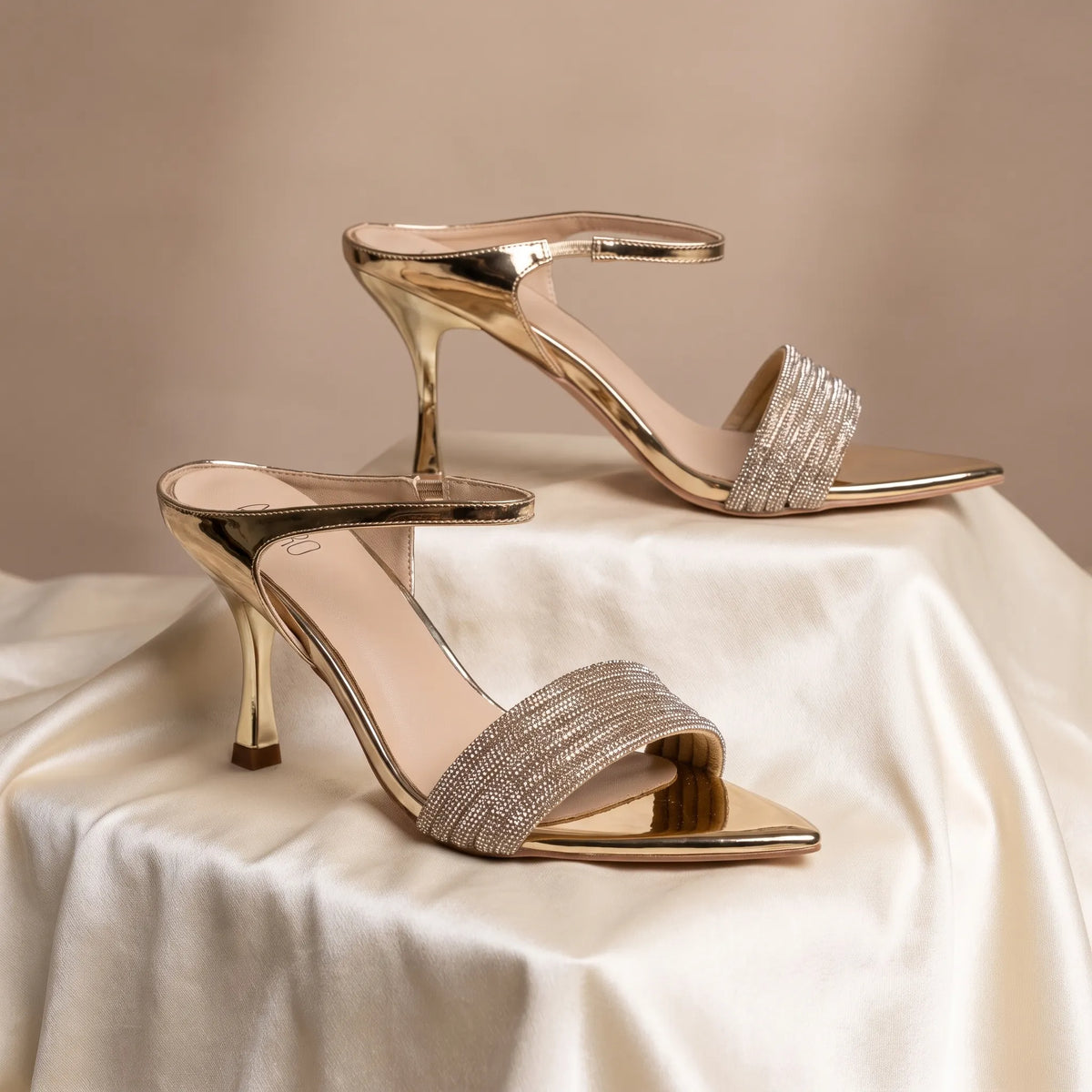 Open-toe slip-on heels with layered embellished straps and a curved sculpted heel.