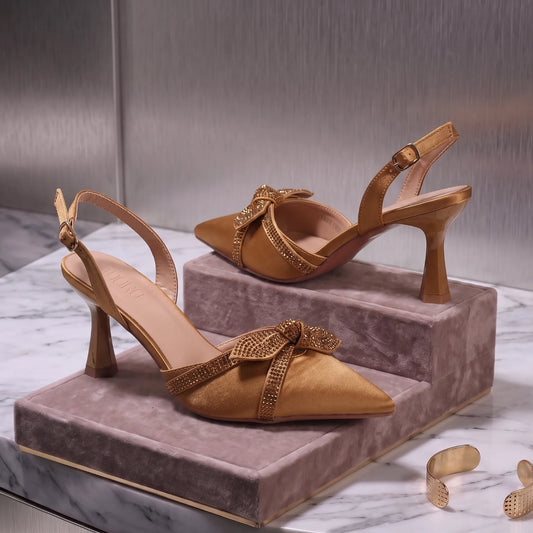 Pointed-toe slingback court shoes with a stone-trimmed bow and flared heel.