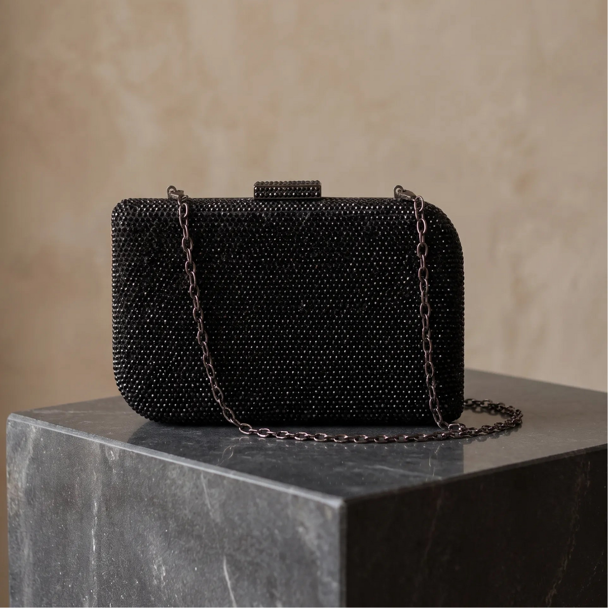 Rectangular clutch with dense faceted embellishments, rounded corners and a top clasp.