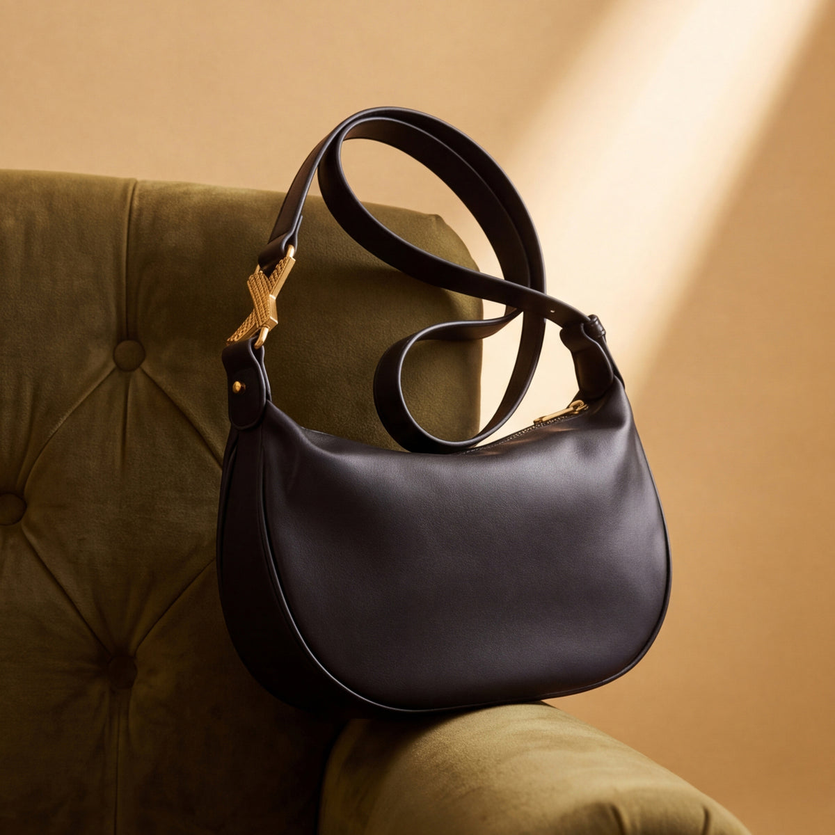 A black crescent-shaped bag with a long strap.